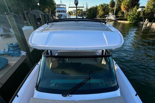 Slide: The Image of 2023 Axopar 37 Sun-Top boat docked in a scenic marina. - 26