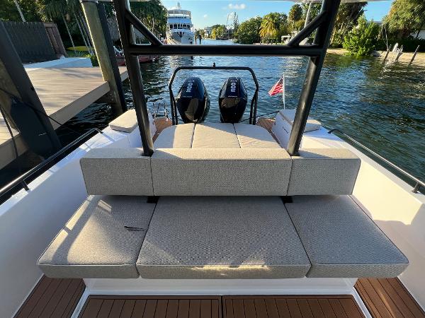Slide: The Image of 2023 Axopar 37 Sun-Top boat with cushioned seating and twin outboard motors. - 28
