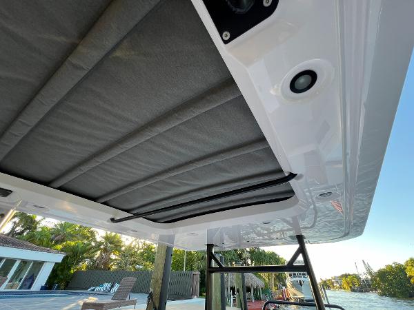 Slide: The Image of 2023 Axopar 37 Sun-Top boat canopy and roof details by the water. - 32