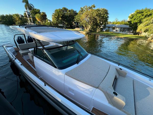 Slide: The Image of 2023 Axopar 37 Sun-Top boat docked by a scenic waterfront. - 8