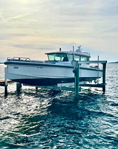 Slide: The Image of Axopar 37XC CROSS CABIN 2018 boat docked on a lift over water. - 0