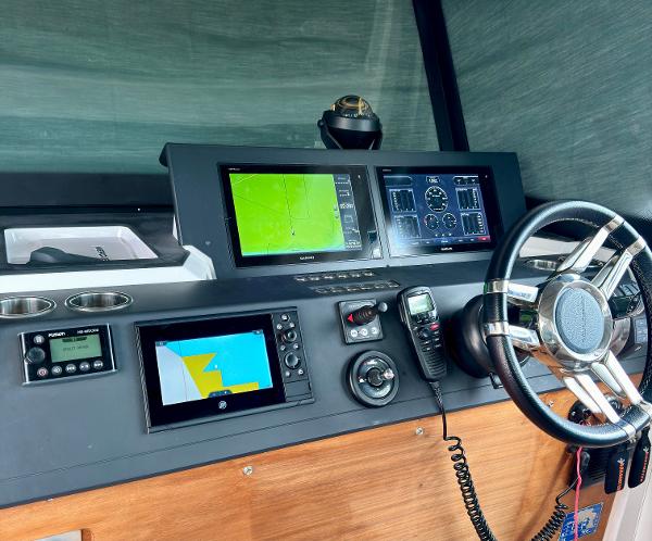 Slide: The Image of Control panel of a 2018 Axopar 37XC CROSS CABIN with navigation screens and steering wheel. - 22