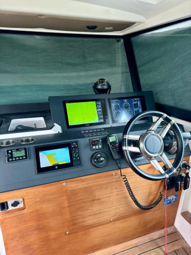 Slide: The Image of 2018 Axopar 37XC CROSS CABIN helm with navigation screens and steering wheel. - 23