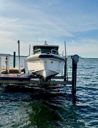 Slide: The Image of Axopar 37XC CROSS CABIN 2018 boat docked on a lift over water. - 3