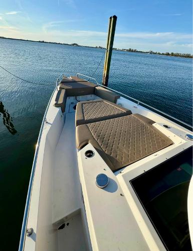 Slide: The Image of Axopar 37XC CROSS CABIN 2018 boat with cushioned deck, docked on calm water. - 5