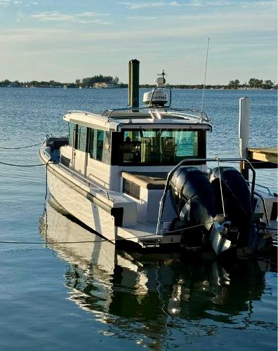 Slide: The Image of 2018 Axopar 37XC CROSS CABIN boat docked on calm water. - 7