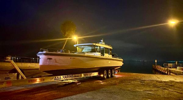 Slide: The Image of Axopar 37XC CROSS CABIN 2018 boat on trailer at night by the water. - 9