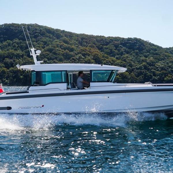 Slide: The Image of 2024 Axopar 37 XC Cross Cabin Wet Bar cruising on a scenic lake. - 0