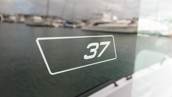 Slide: The Image of Axopar 37 XC Cross Cabin Wet Bar 2024 boat window with "37" decal. - 19