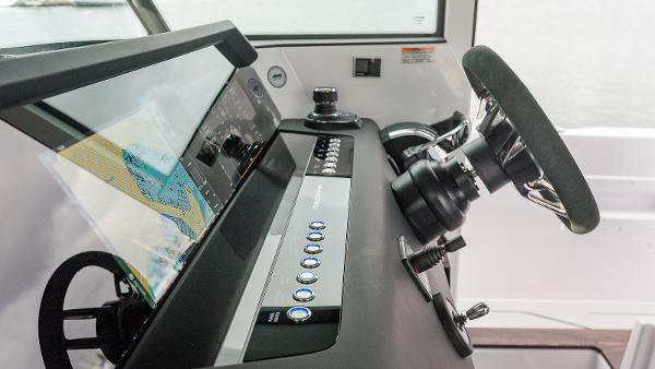 Slide: The Image of 2024 Axopar 37 XC Cross Cabin helm with navigation display and controls. - 6