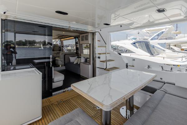 Slide: The Image of Azimut 60 Flybridge 2021 yacht interior with elegant seating and dining area. - 15