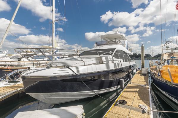 Slide: The Image of Azimut 60 Flybridge 2021 yacht docked under a blue sky with clouds. - 3