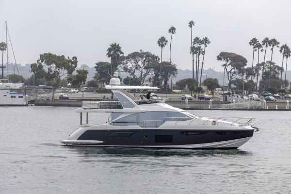 Slide: The Image of 2021 Azimut 60 Flybridge yacht cruising near palm-lined shore. - 6