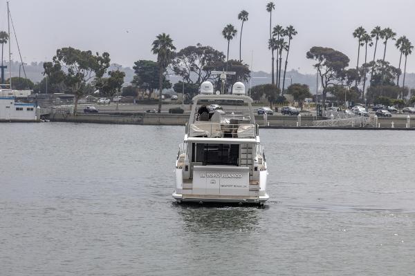 Slide: The Image of Azimut 60 Flybridge 2021 yacht cruising near a marina with palm trees. - 9