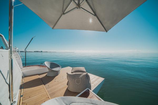 Slide: The Image of Azimut Magellano 25 Metri 2023 yacht deck with ocean view, umbrella, and seating. - 11