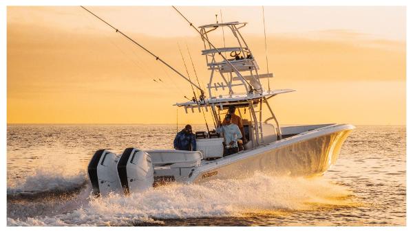 Slide: The Image of 2024 Bahama 41 Super Center Console boat cruising at sunset. - 2