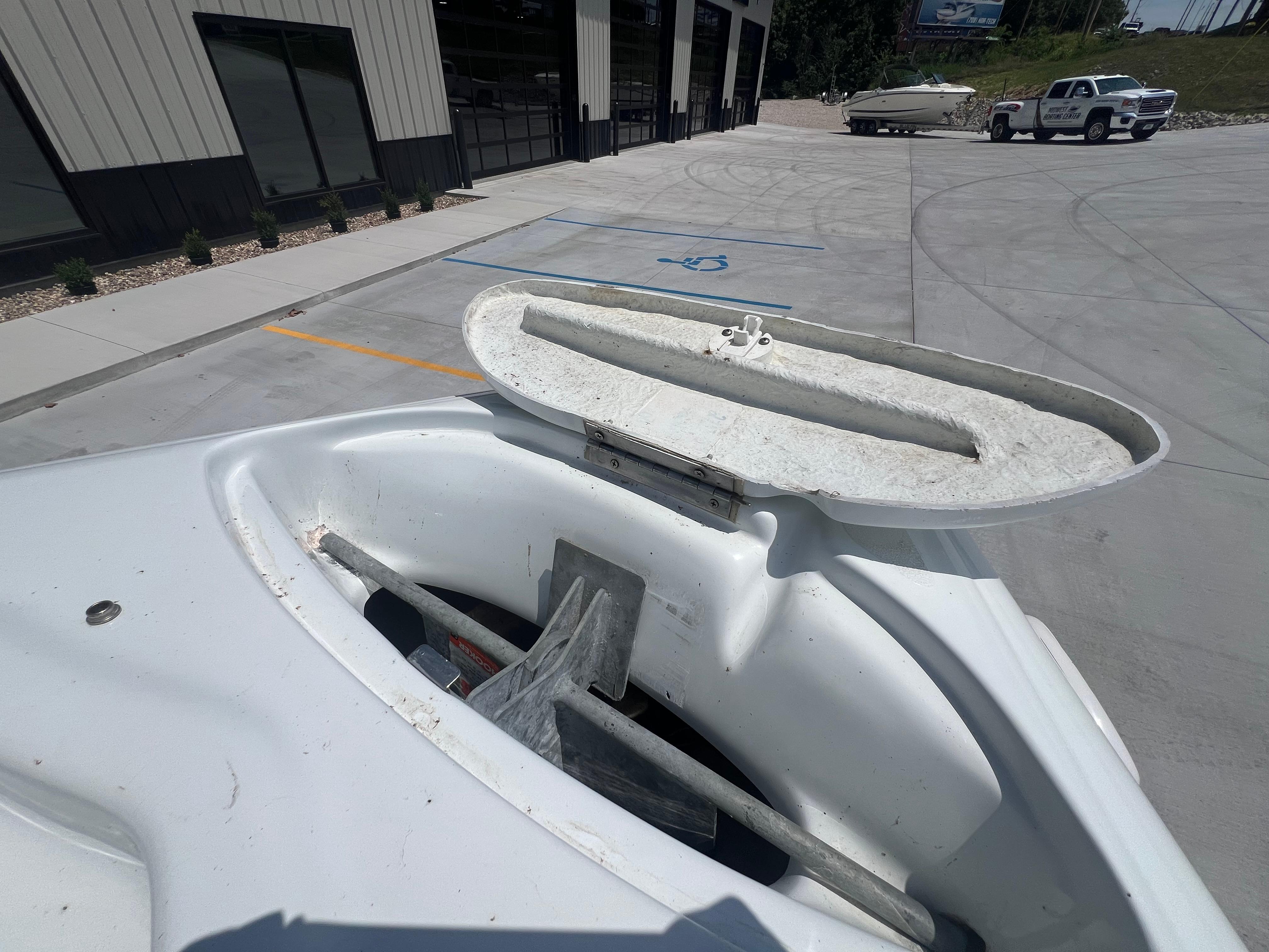Slide: The Image of 1999 Baja 272 Islander boat anchor compartment open in a parking lot. - 12