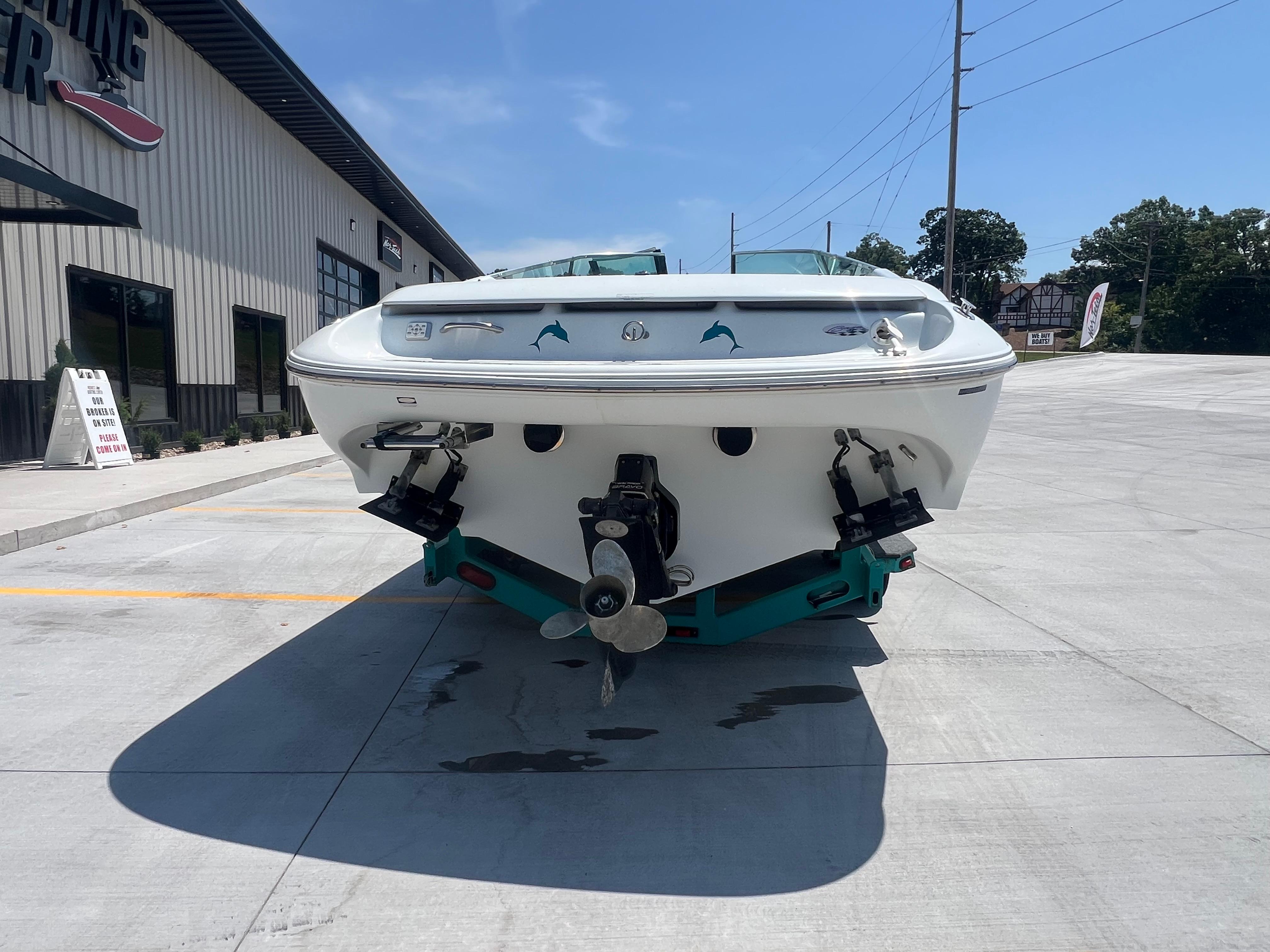 Slide: The Image of 1999 Baja 272 Islander boat on concrete, rear view, near a building. - 2