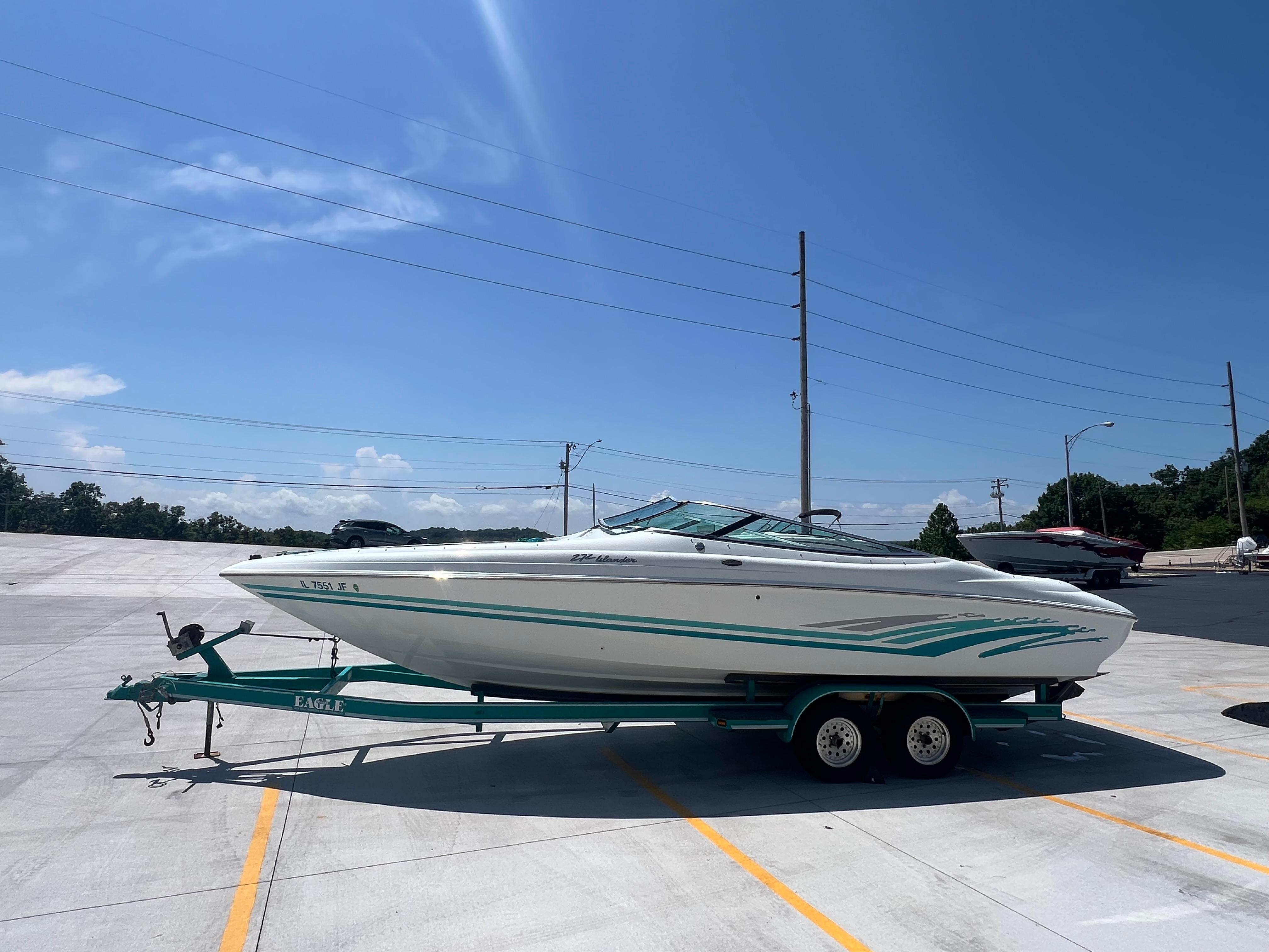 Slide: The Image of 1999 Baja 272 Islander boat on trailer under clear blue sky. - 4