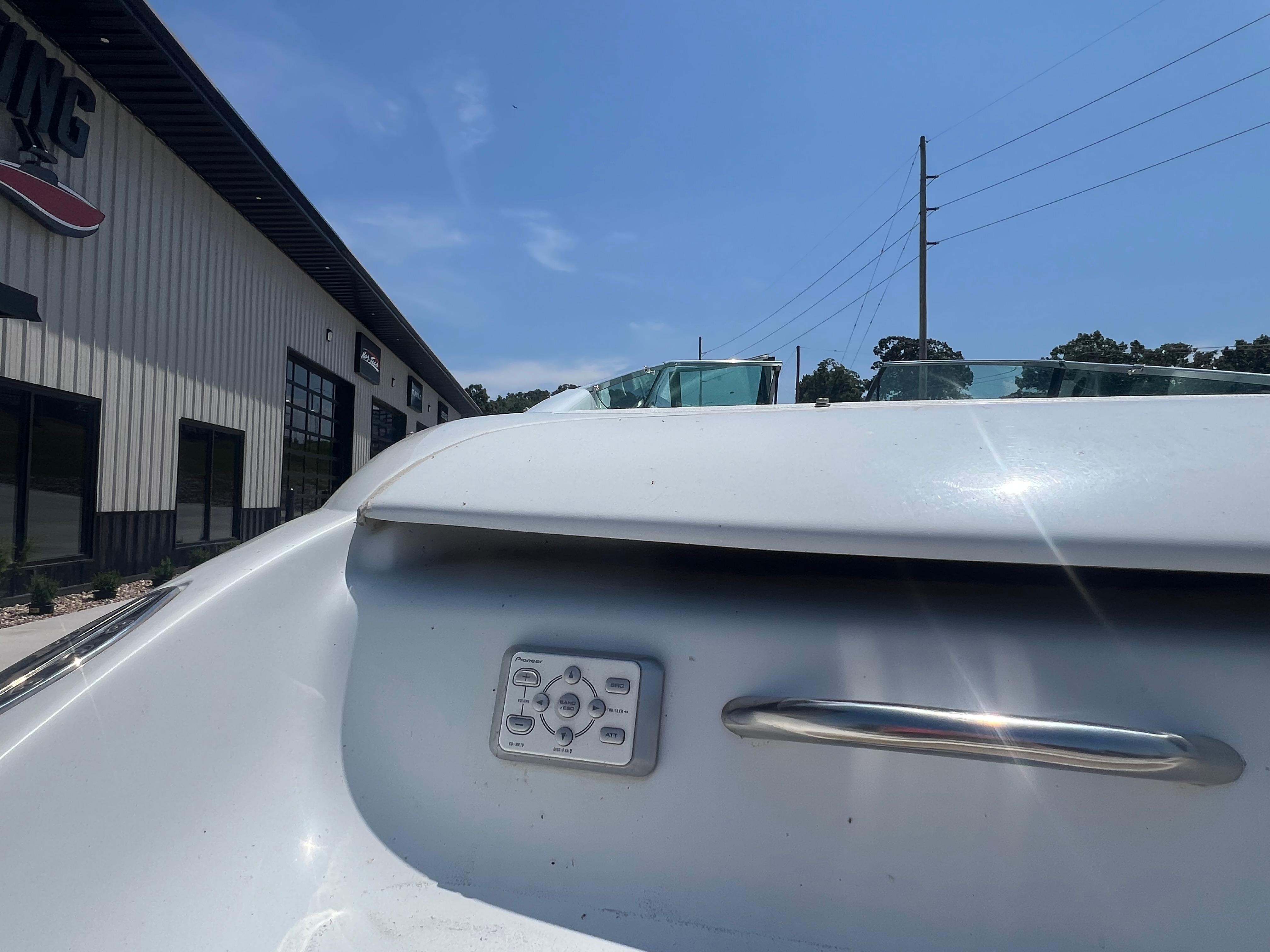 Slide: The Image of 1999 Baja 272 Islander boat detail with control panel and handle, outdoors under clear sky. - 6