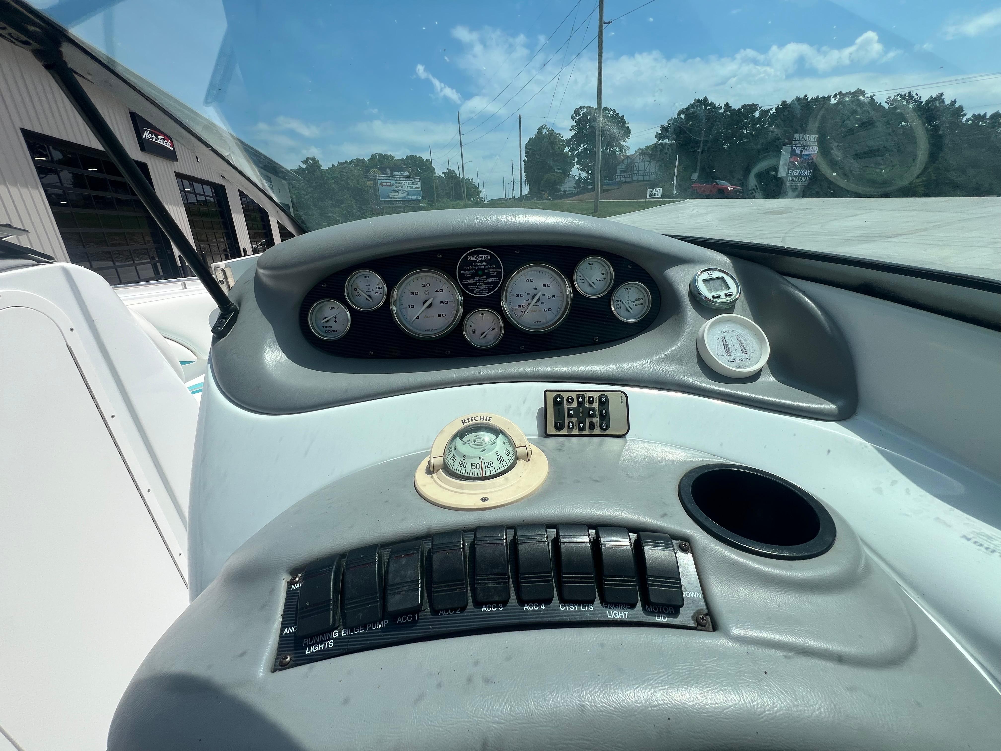 Slide: The Image of 1999 Baja 272 Islander boat dashboard with gauges and controls under a clear sky. - 9