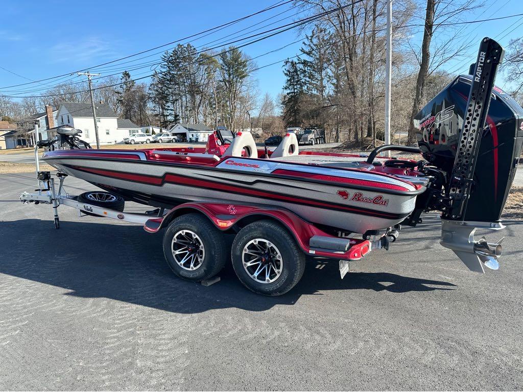 Slide: The Image of 2024 Bass Cat Boats Caracal STS on trailer, red and gray, parked outdoors. - 13