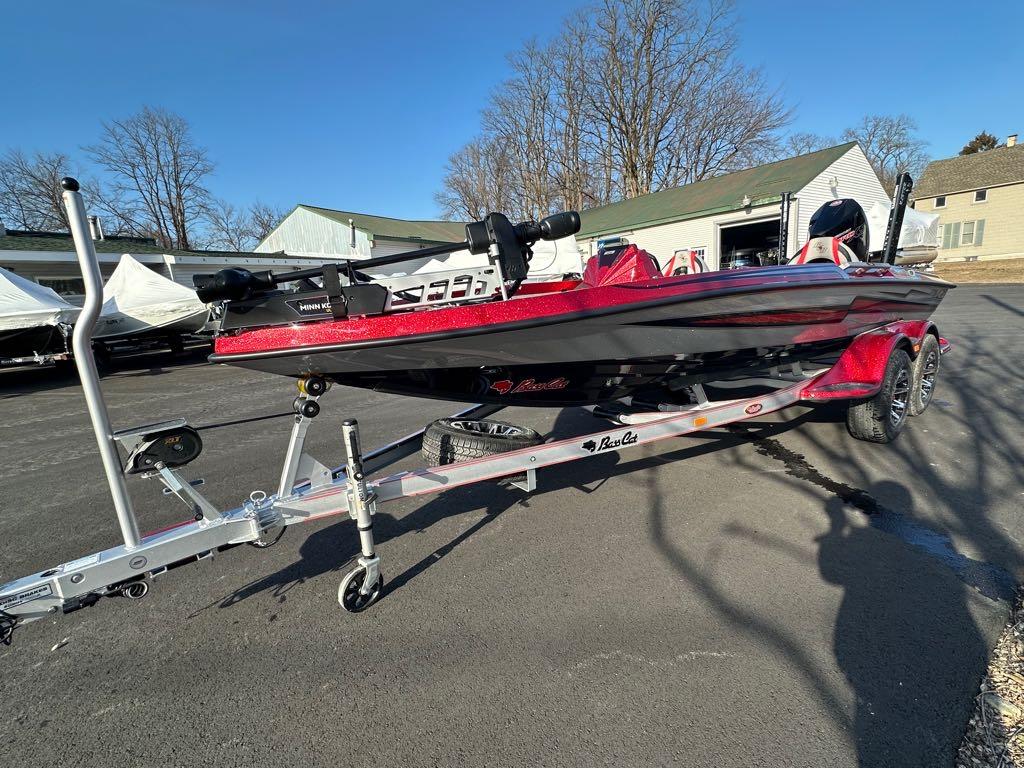 Slide: The Image of 2024 Bass Cat Boats Caracal STS on trailer, red and black, outdoor setting. - 3