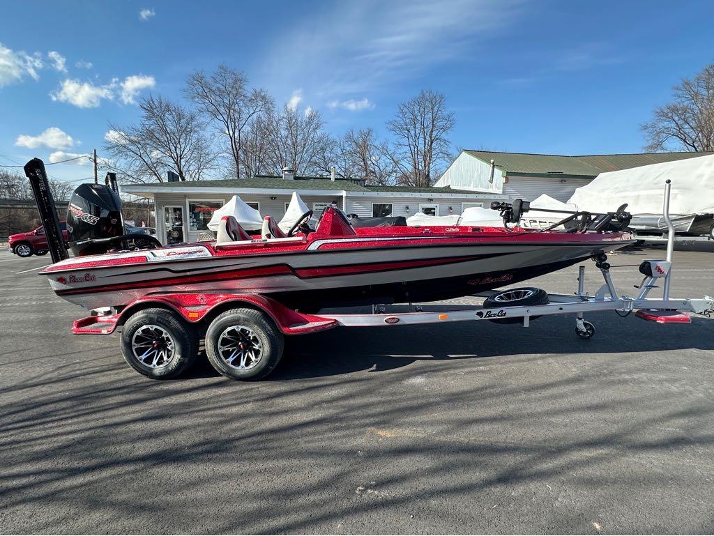 Slide: The Image of 2024 Bass Cat Boats Caracal STS on trailer, red and white, parked outdoors. - 8