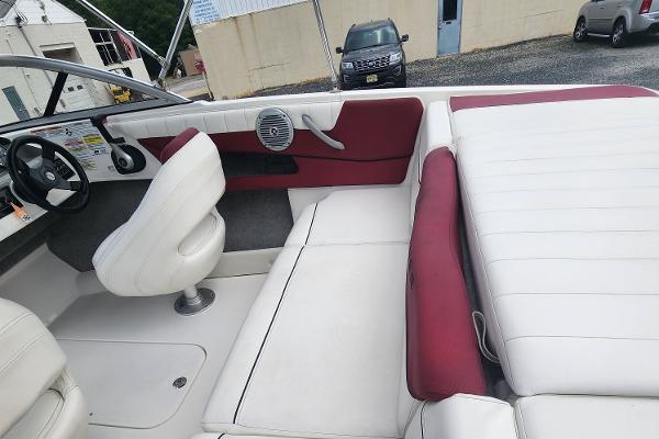 Slide: The Image of 2018 Bayliner 185 Bowrider interior with white and red seating, steering wheel, and speaker. - 13