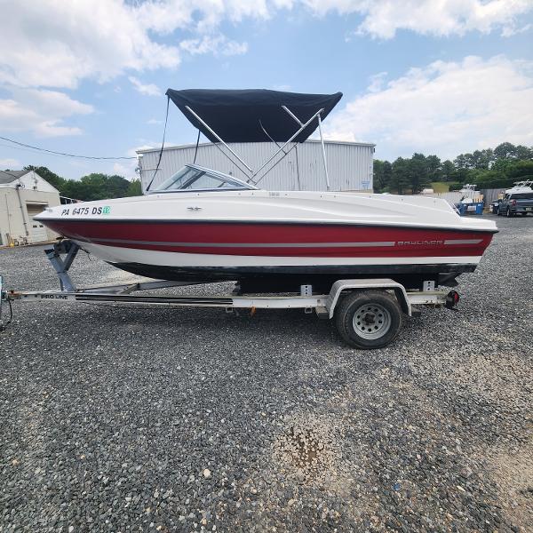 Slide: The Image of 2018 Bayliner 185 Bowrider on trailer, red and white, with black canopy. - 4