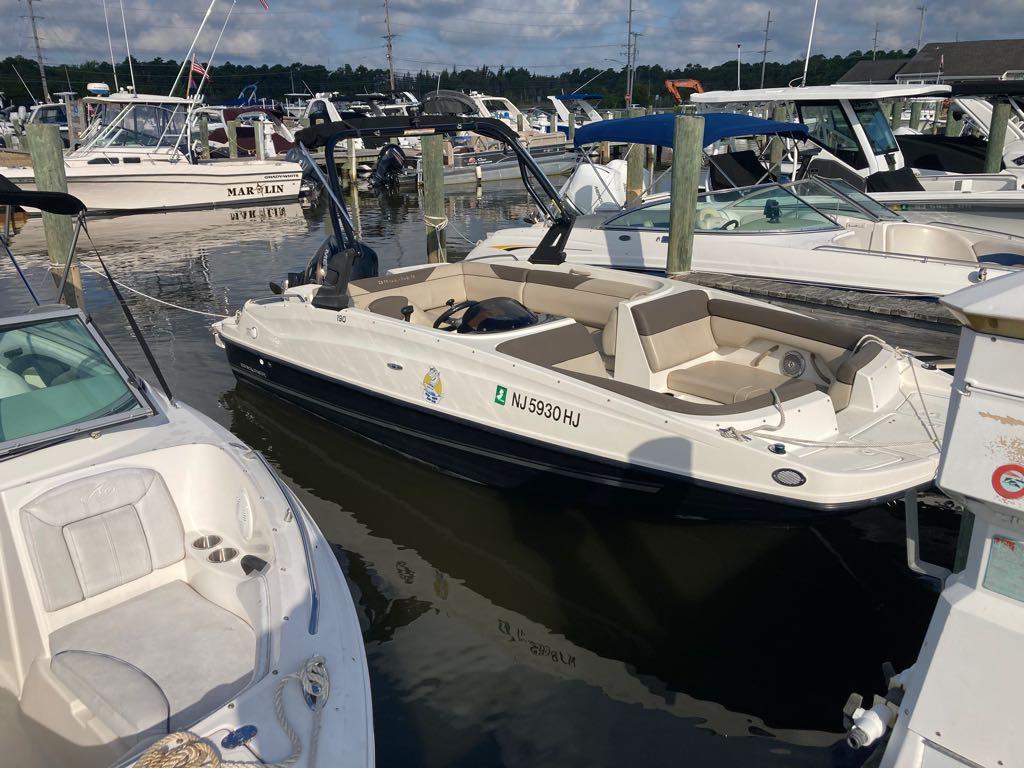 Slide: The Image of 2017 Bayliner 190 boat docked at a marina with other boats. - 1