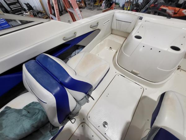 Slide: The Image of 2006 Bayliner 192 Discovery boat interior with blue and white seating, storage compartments. - 10