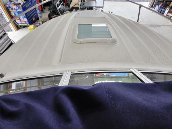 Slide: The Image of 2006 Bayliner 192 Discovery boat deck with hatch, viewed from above in a garage setting. - 22