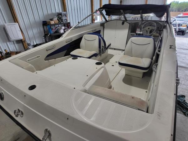Slide: The Image of 2006 Bayliner 192 Discovery boat interior with white seating and steering wheel in a garage. - 23