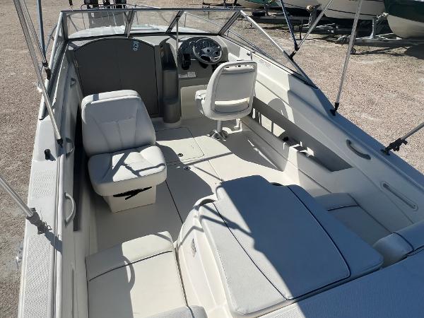 Slide: The Image of 2012 Bayliner 192 Discovery boat interior with seating and steering console. - 12