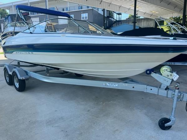 Slide: The Image of 1995 Bayliner 2050 Capri boat on trailer, under a covered area. - 0