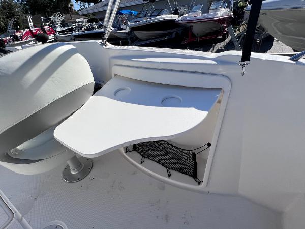 Slide: The Image of 2018 Bayliner 210 Deck Boat interior with seating and foldable table. - 13