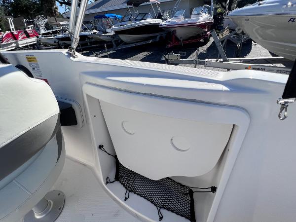 Slide: The Image of 2018 Bayliner 210 Deck Boat interior with storage compartment and seating. - 14