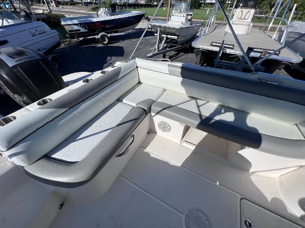 Slide: The Image of 2018 Bayliner 210 Deck Boat interior seating area with white and gray upholstery. - 17