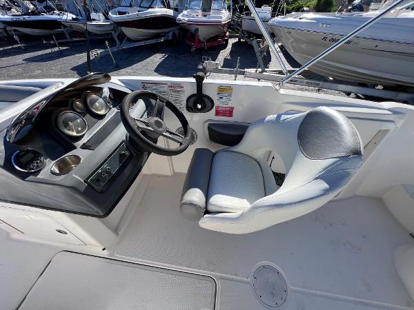Slide: The Image of 2018 Bayliner 210 Deck Boat cockpit with steering wheel and captain's chair. - 18