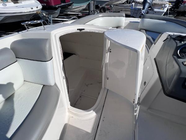 Slide: The Image of 2018 Bayliner 210 Deck Boat interior storage compartment with open door. - 21