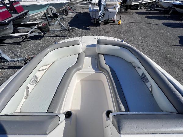 Slide: The Image of 2018 Bayliner 210 Deck Boat with spacious seating and storage, docked in a marina. - 23