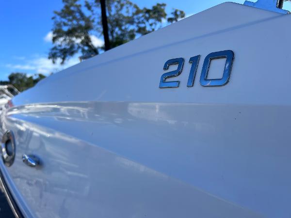 Slide: The Image of Close-up of 2018 Bayliner 210 Deck Boat exterior with model number. - 4