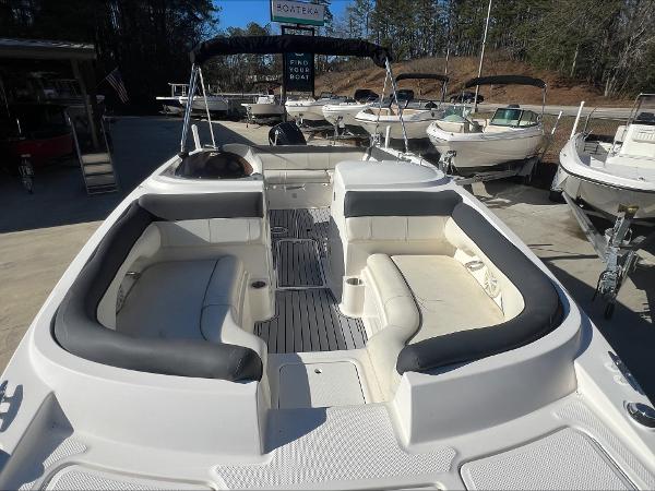 Slide: The Image of 2018 Bayliner 210 Deck Boat with spacious seating and sleek design at a marina. - 6