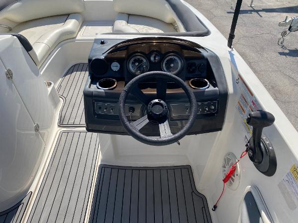 Slide: The Image of 2018 Bayliner 210 Deck Boat cockpit with steering wheel and control panel. - 7