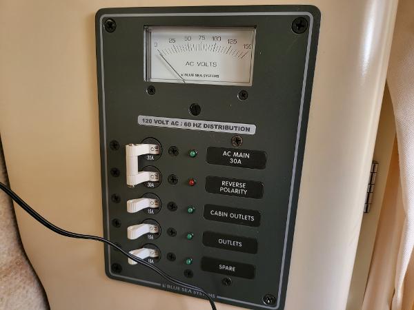 Slide: The Image of 1995 Bayliner 2355 Ciera Sunbridge electrical panel with AC voltmeter and circuit breakers. - 16