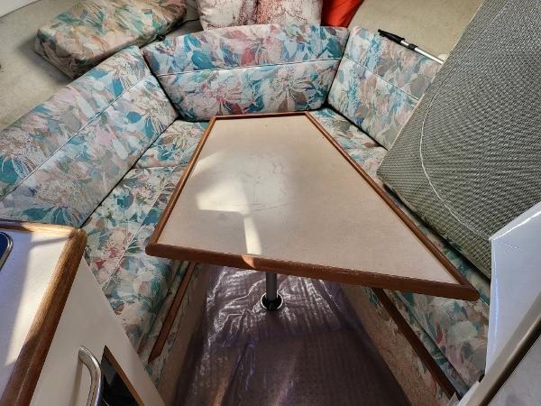 Slide: The Image of Interior seating area of 1995 Bayliner 2355 Ciera Sunbridge with floral upholstery and table. - 6