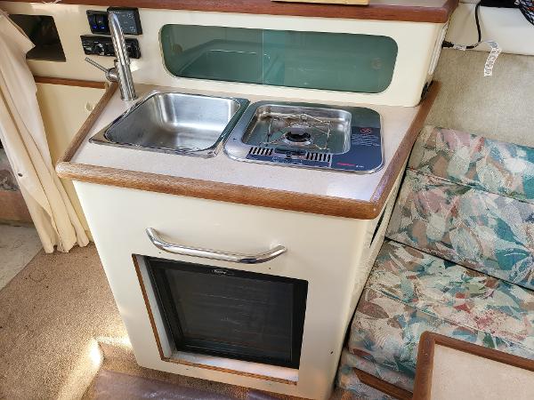 Slide: The Image of Compact kitchen area in a 1995 Bayliner 2355 Ciera Sunbridge boat with sink and stove. - 7