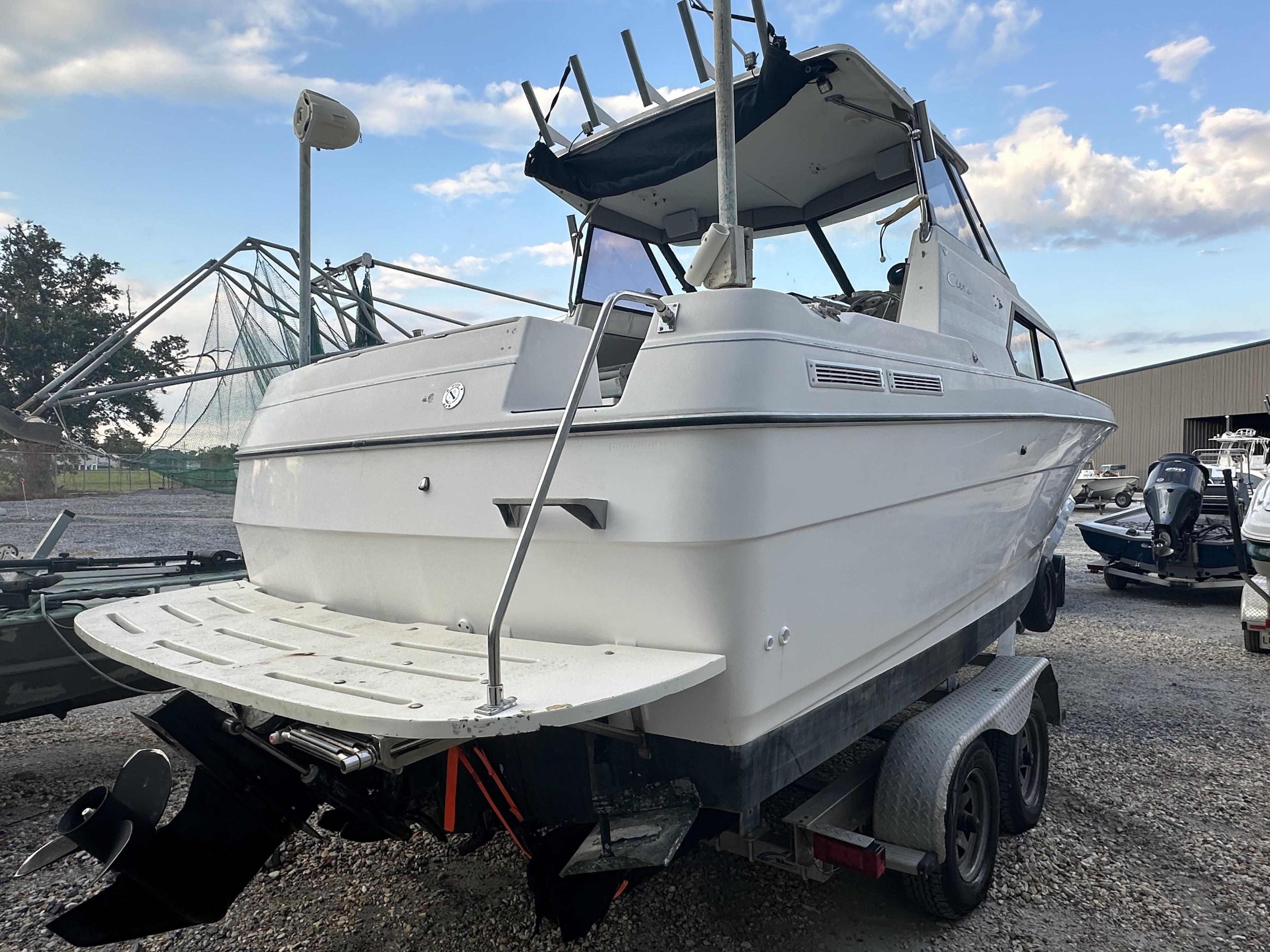 Slide: The Image of 1998 Bayliner 2452 Ciera Express boat on trailer, parked outdoors under a blue sky. - 10