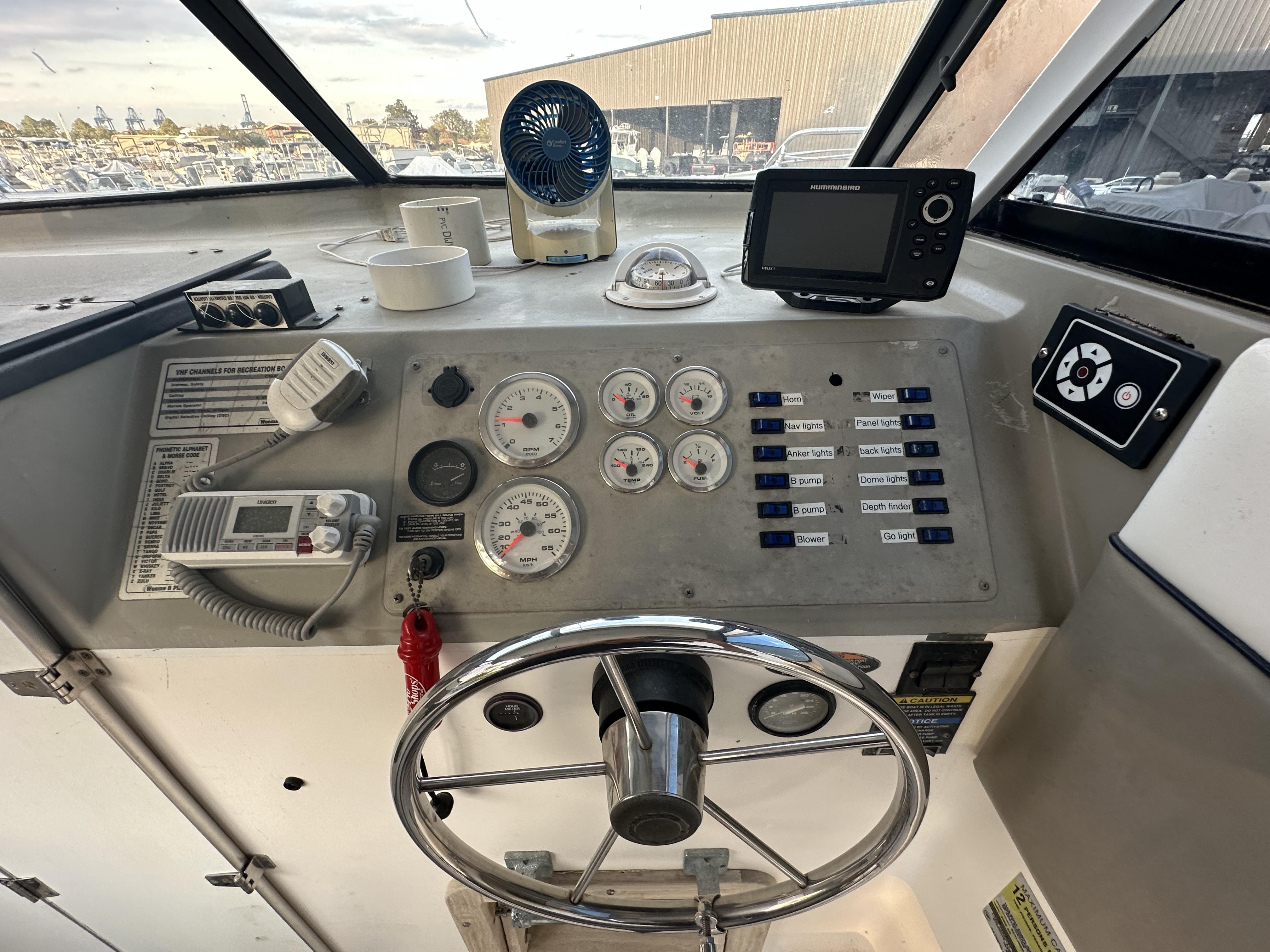 Slide: The Image of 1998 Bayliner 2452 Ciera Express dashboard with steering wheel, gauges, and navigation equipment. - 11